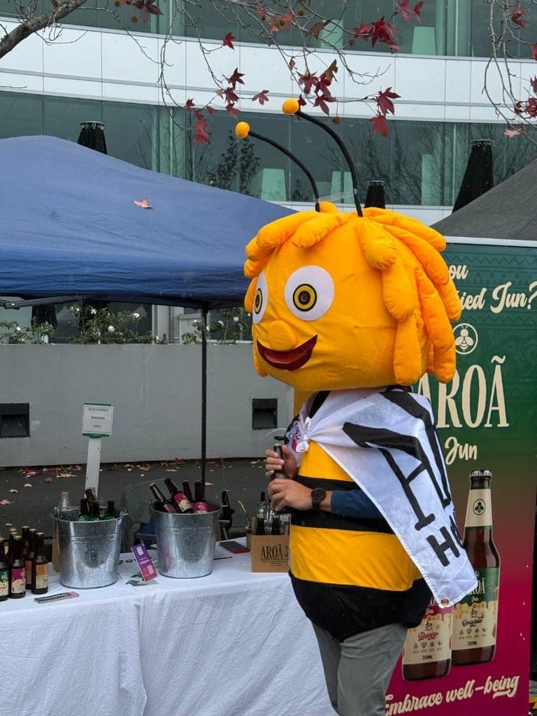 The Aroā bee chatting with a young family at the market stand